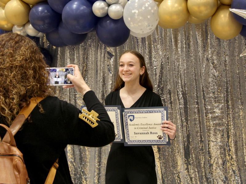 Penn State DuBois student Savannah Ross pauses with her awards for a photo, taken by a family member, at the recognition and awards banquet at the PAW Center.